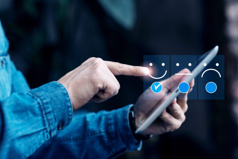 Uma pessoa de camisa jeans usa um tablet, selecionando um rosto feliz com uma marca de seleção em uma pesquisa de feedback digital, reforçando a importância da satisfação do cliente com opções de ícones felizes, neutros e tristes.