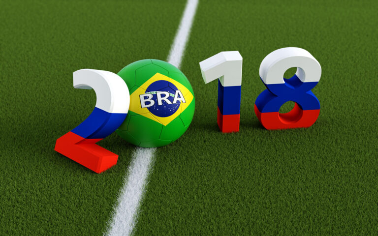 A imagem destaca 2018 na grama, com o 0 substituído por uma bola de futebol com a bandeira brasileira. Os números espelham a bandeira russa, enquanto uma linha branca corre abaixo - perfeita para temas sobre a comercialização de álbuns e figurinhas da Copa.