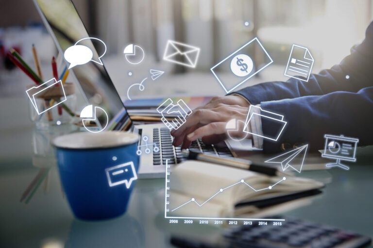 Uma pessoa digitando em um laptop em uma mesa com uma xícara de café, um caderno e canetas, cercada por ícones digitais que representam as 7 páginas que todo empreendedor lotérico precisa - com foco em comunicação, documentos, gráficos e dados financeiros.