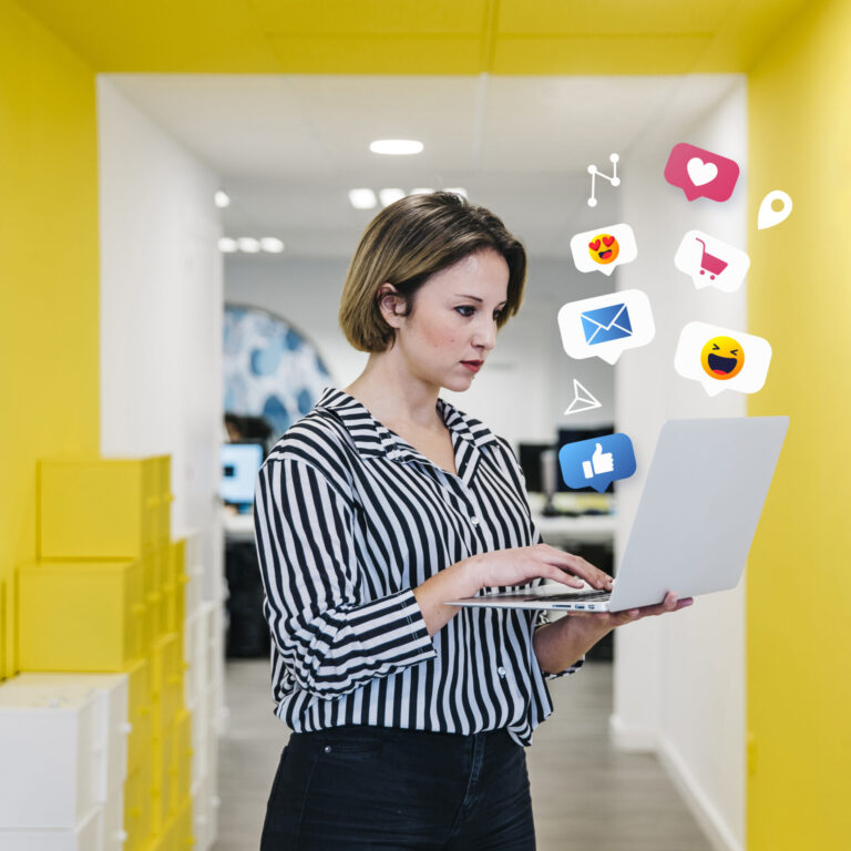 Uma mulher de camisa listrada está em um corredor amarelo brilhante, trabalhando em um laptop. Ícones coloridos de mídia social flutuam ao seu redor, destacando as formas de atrair clientes para a América Latina na era digital.